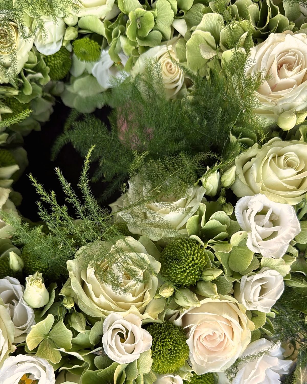 Weiße Rosen und Eustoma mit Hortensie und grünen Chrysanthemen, nah fotografiert